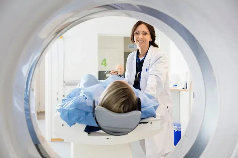 technician helping patient in MRI machine