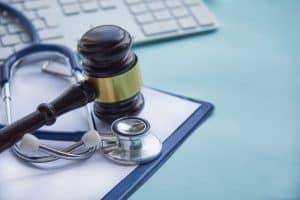 gavel and stethoscope on top of medical chart