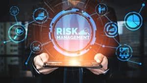 man holding tablet with abstract graphics saying risk management