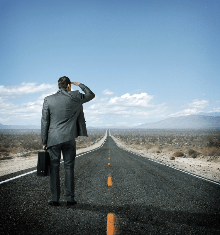 business man looking down long road