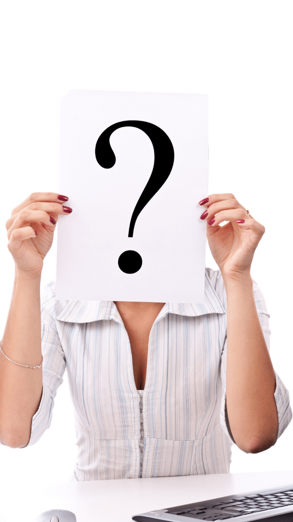 person holding question mark in front of face