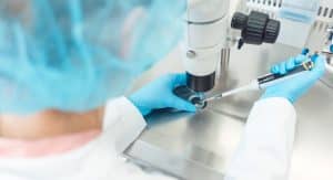 medical professional using microscope