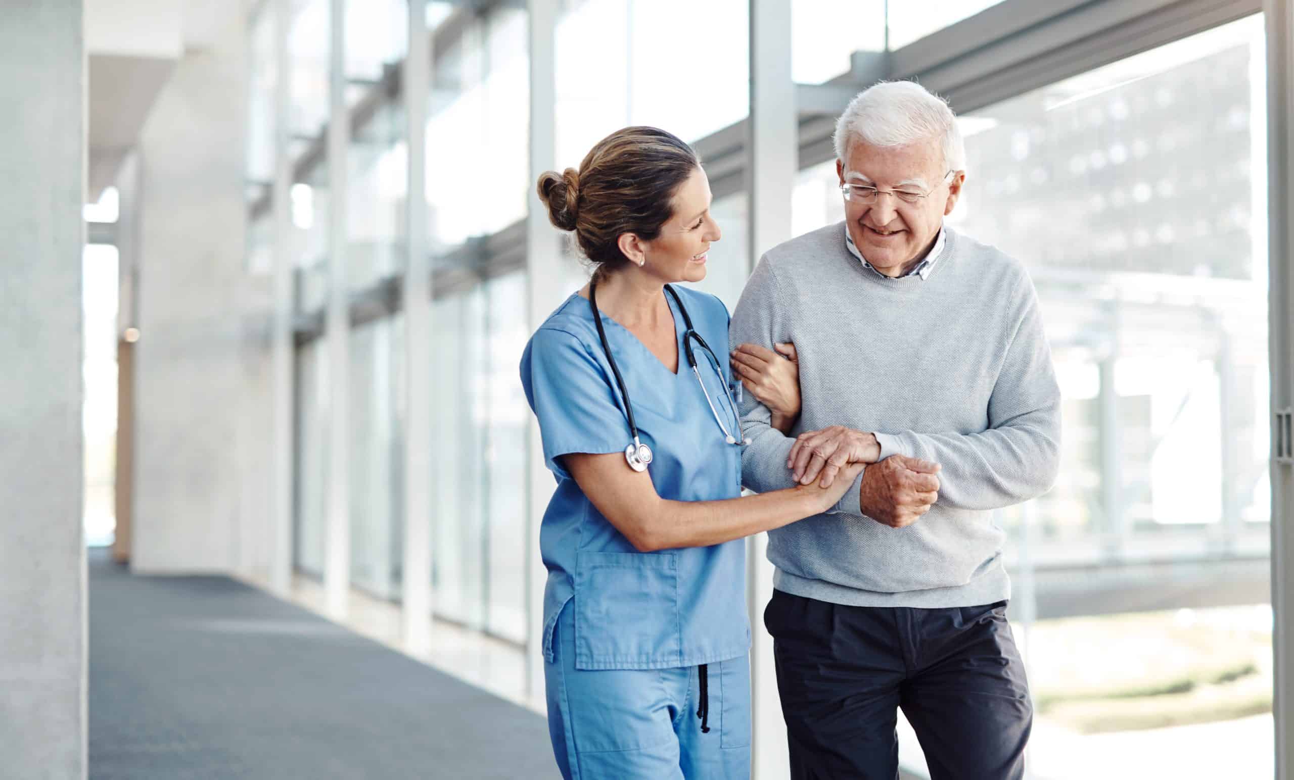 Nurse walking and supporting elderly patient
